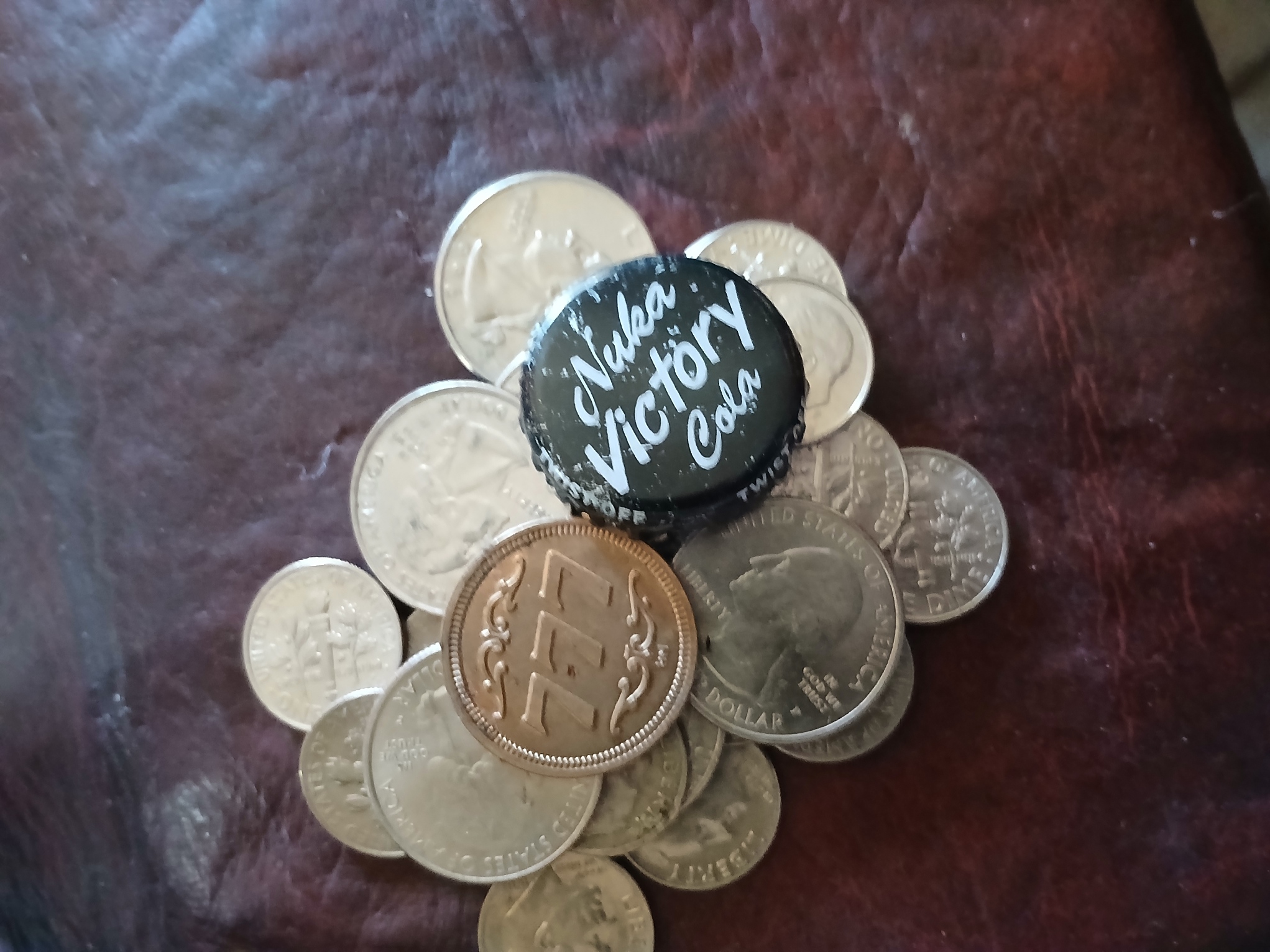 A pile of coins, a pachinko token, and a bottle cap.